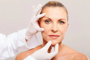 doctor doing skin check on middle woman before cosmetic surgery stock image