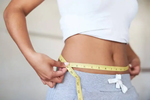 young woman measuring her waist stock image