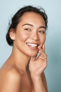 Smiling asian woman touching healthy skin portrait stock image